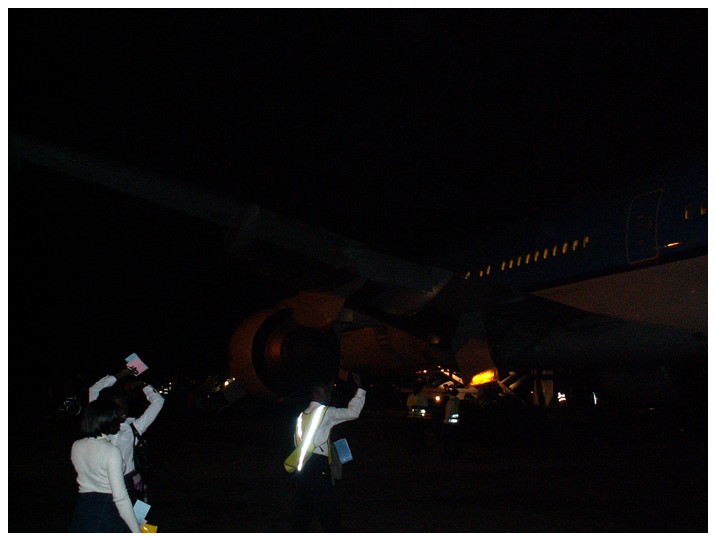 P marken i Accra. Lysande och viftande markpersonal. Mrkt stort flygplan. Jag fick bannor fr att jag tog den hr bilden.